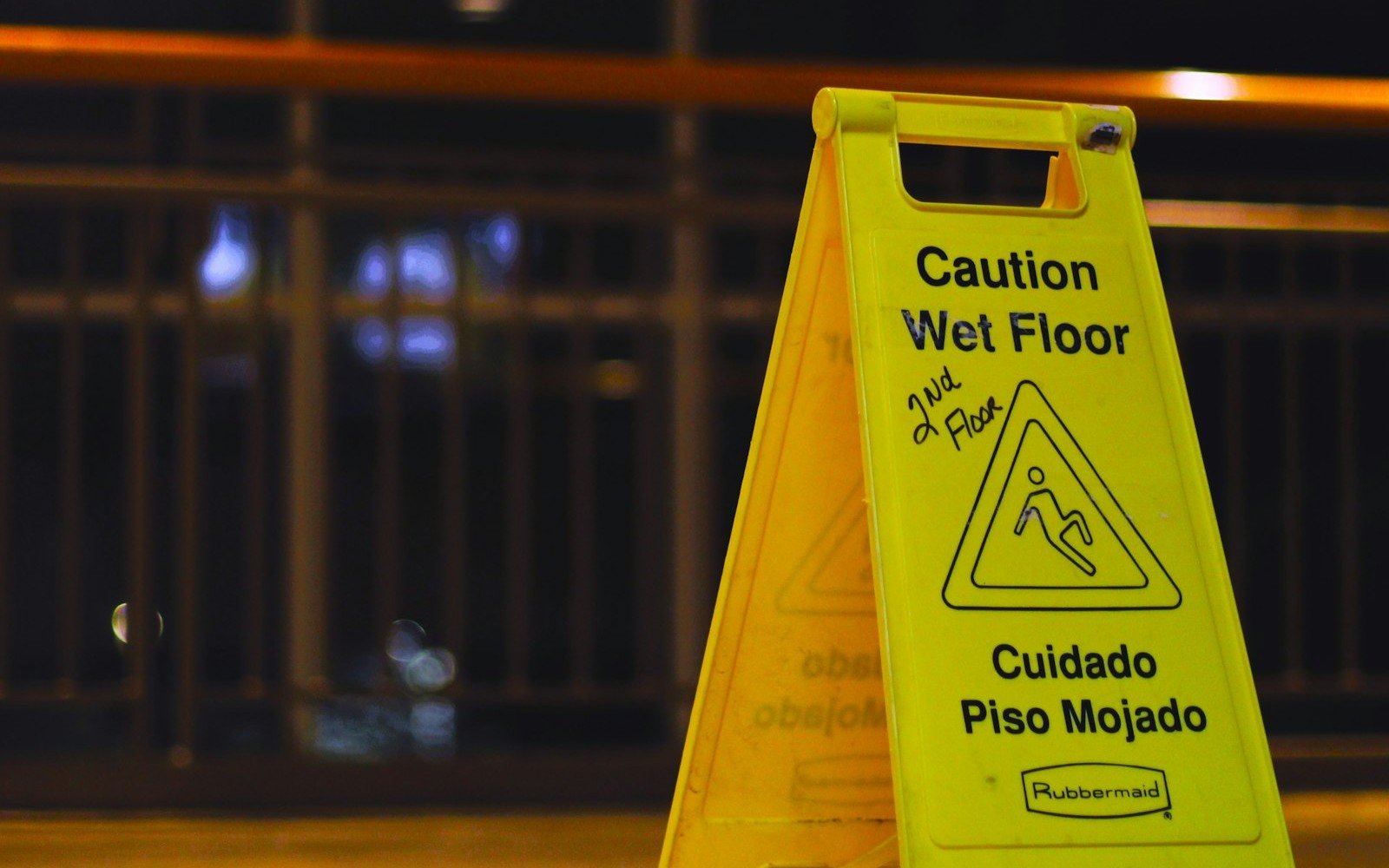 Bilingual caution wet floor sign representing personal injury and slip and fall claims in Colombia