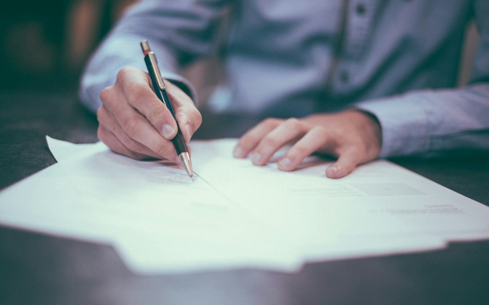 Signing a legal document, representing suing a Colombian employer for wrongful dismissal